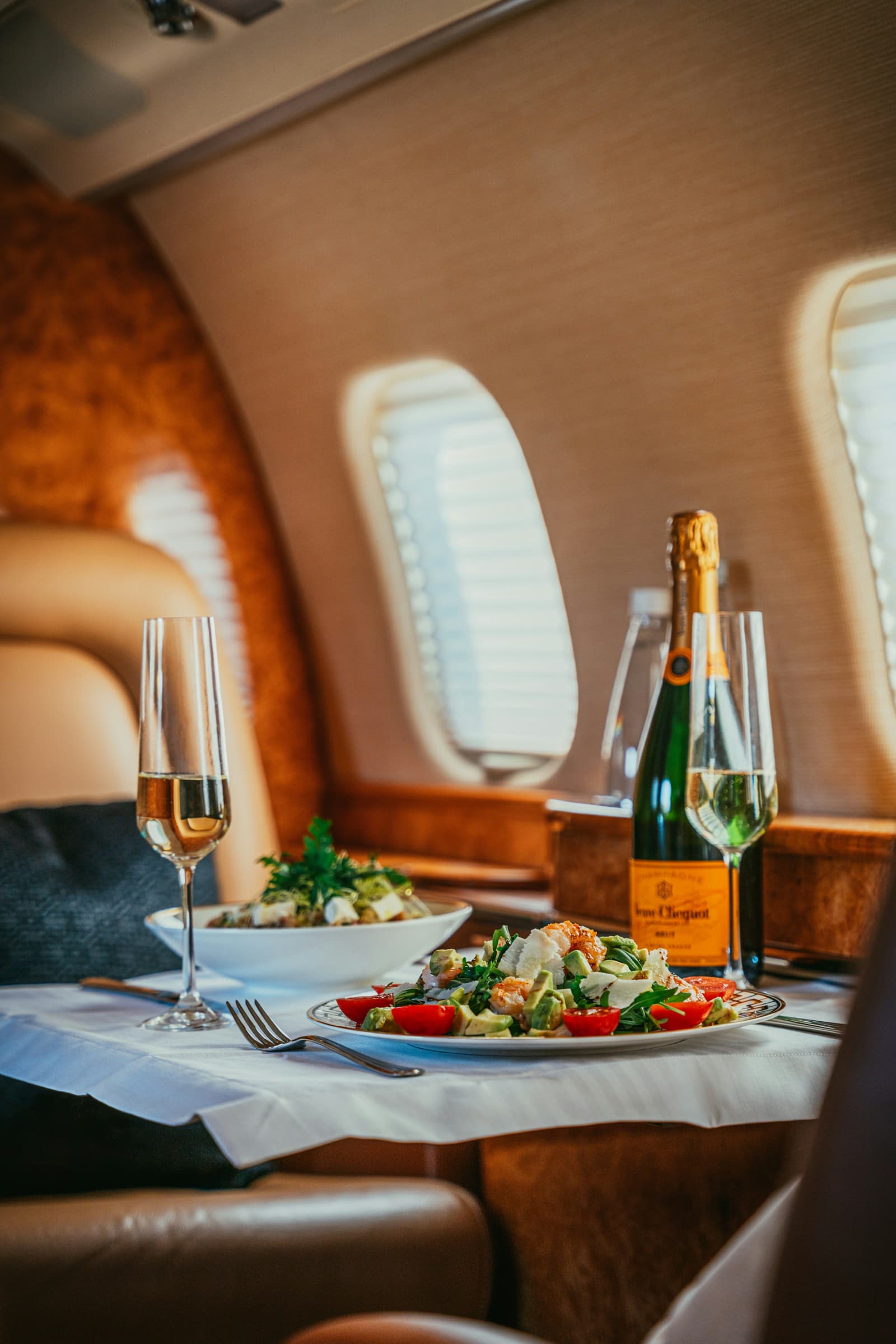 Champagne and catering set out aboard a private jet cabin